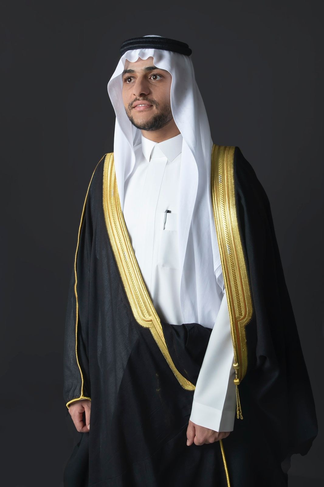 بورتريه رسمي لشخصية بالزي السعودي التقليدي والبشت الفاخر بإضاءة استوديو داكنة